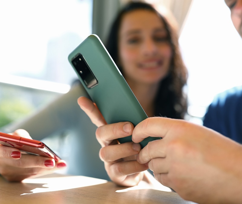 Person mit Gerät versucht herauszufinden, wie sie Spyware auf dem Android-Handy erkennen kann.
