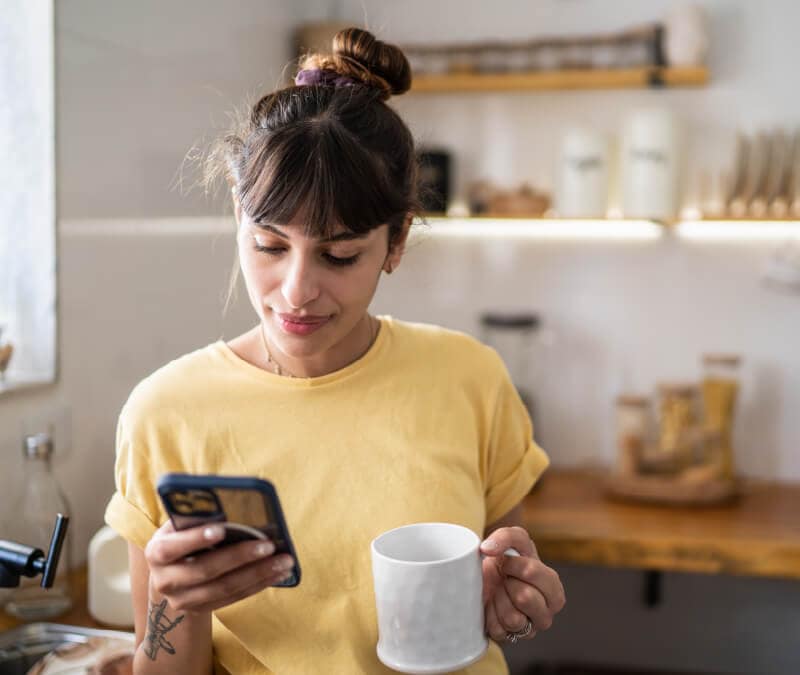 Eine Frau überprüft die Einstellungen ihres Mobiltelefons, um das Mikrofon auszuschalten.