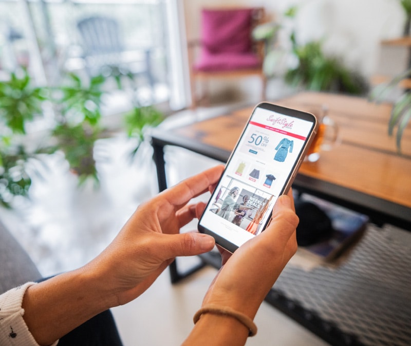 Abbildung: Hände, die ein Smartphone mit einer potenziell schädlichen Werbeanzeige halten