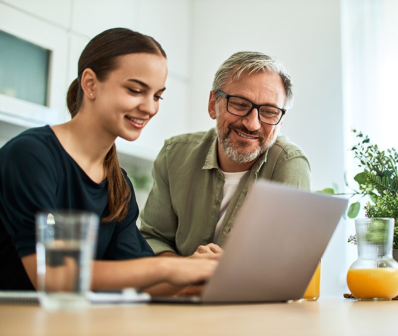 Eine Frau zeigt einem freundlichen Mann in Grün ihren Suchverlauf.
