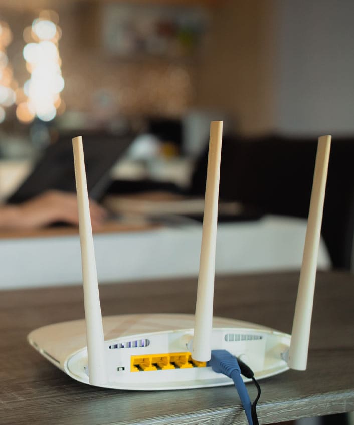 A Wi-Fi router sits on a computer desk shelf.