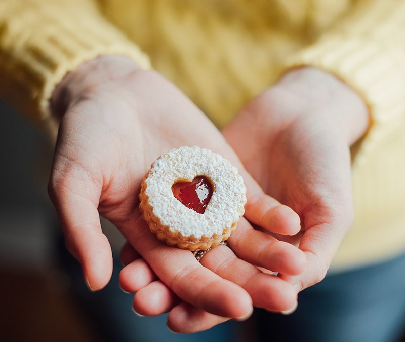 A woman looking confused while holding a laptop with a cookie notification on the screen, captioned "Should you accept cookies?"