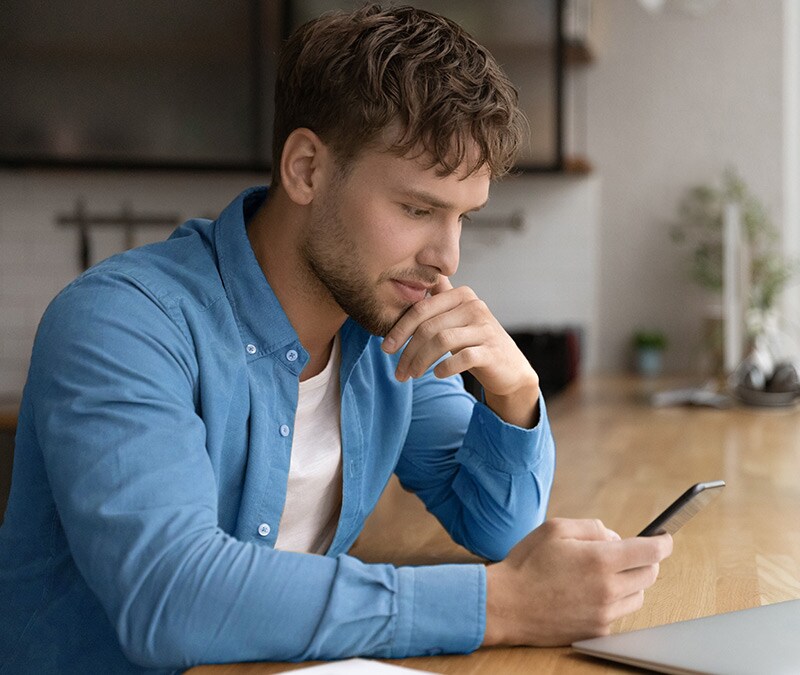 Person mit verwirrtem Gesichtsausdruck blickt auf ihr Handy und fragt sich möglicherweise: „Wie kann ich sehen, ob jemand meine Nummer blockiert hat?“
