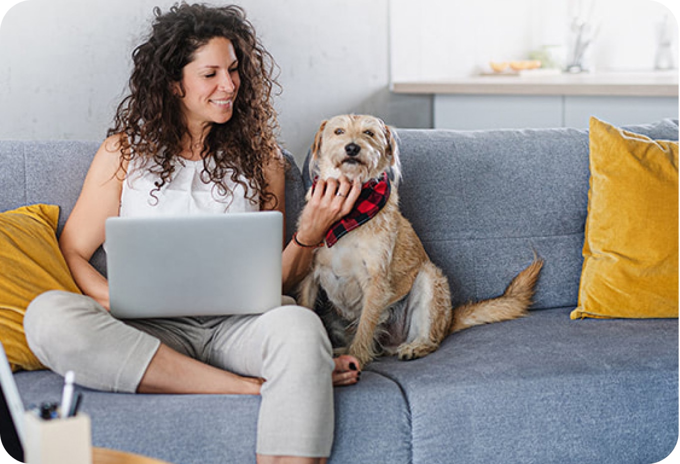 Frau mit Hund auf einer Couch.