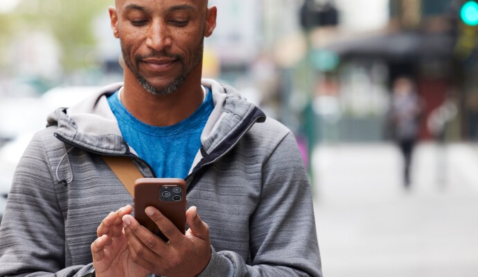 Mann schaut auf sein Mobiltelefon