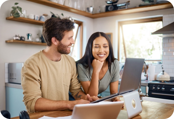Junger Mann am Laptop in der Küche